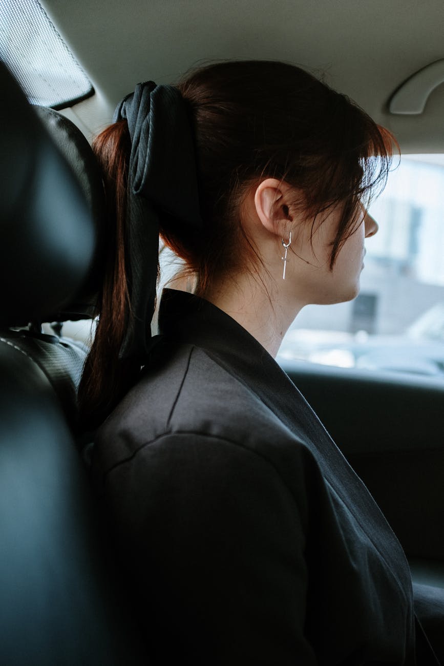 woman in black suit jacket sitting on car seat