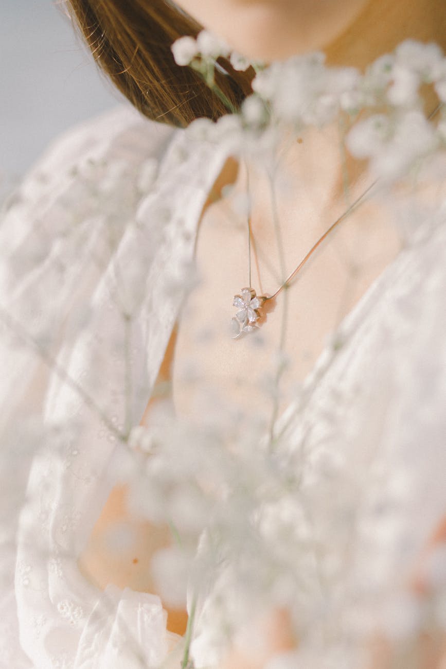 a person wearing necklace with flower pendant